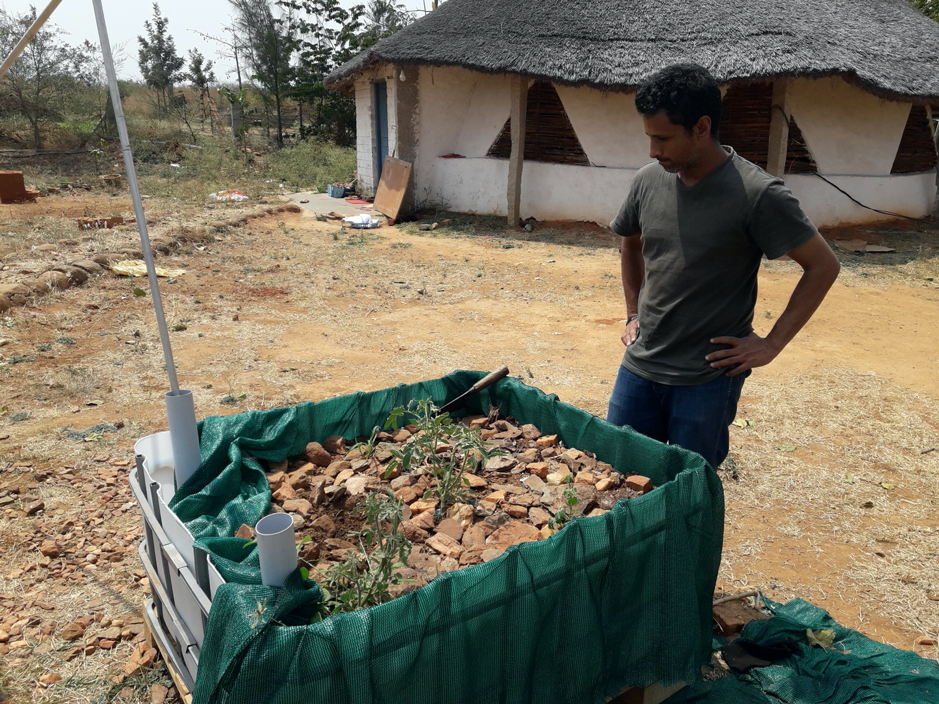 A person standing next to a pile of dirt

Description automatically generated