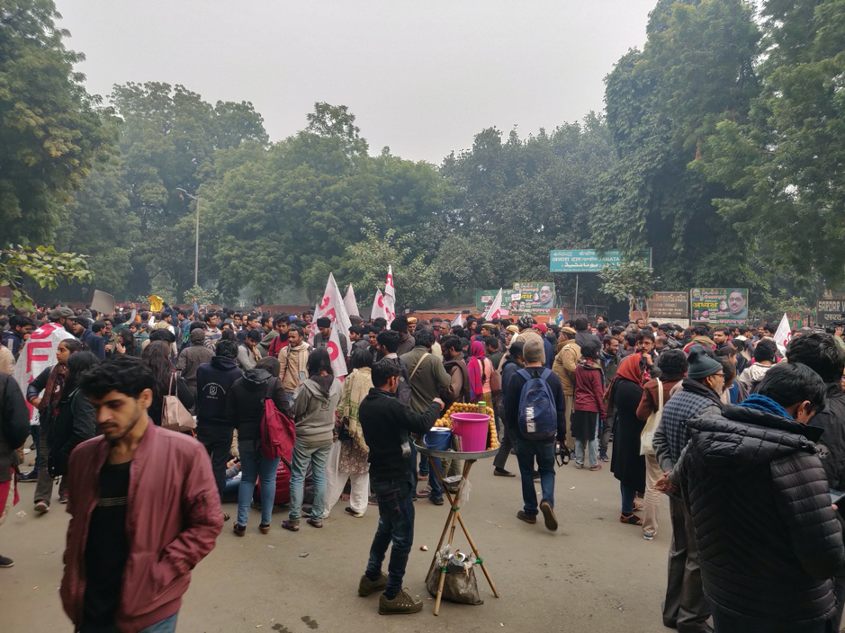 A group of people walking in front of a crowd

Description automatically generated